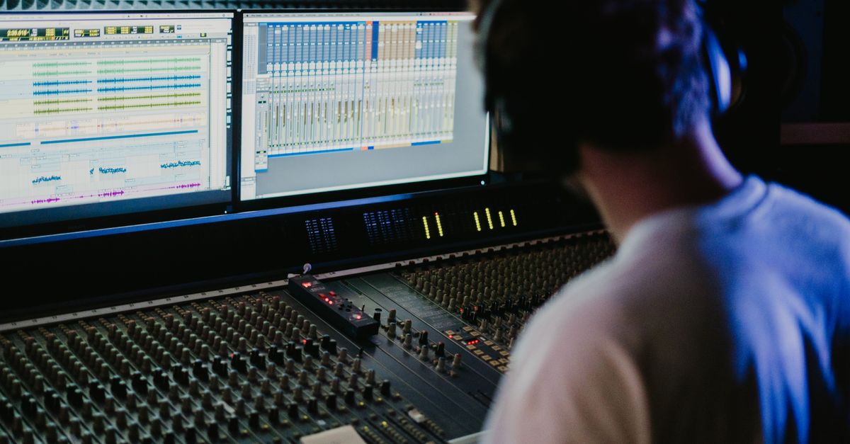 Zvukový inženýr pracující s mixážním pultem ve studiu