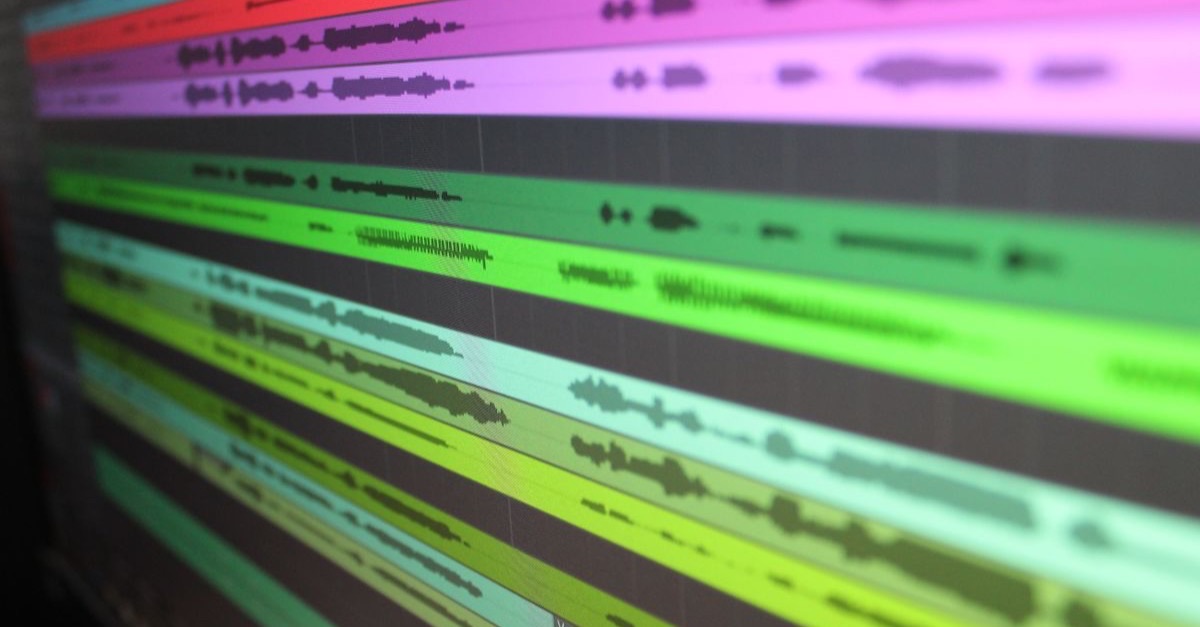 Colour-coded dialogue waveforms across multiple tracks in an audio editing timeline